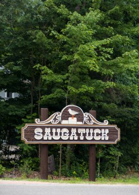 Tarihsel Saugatuck şehri giriş tahtası Michigan 'da yemyeşil ağaçlarla dolu.