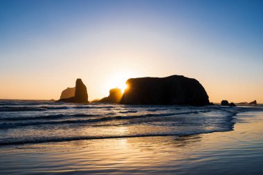 Gün batımında Oregon, Bandon sahilindeki uzun deniz yığınlarının manzarası.