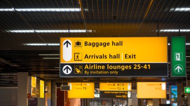Amsterdam, Hollanda - 15 Aralık 2025: Hollanda, Amsterdam 'daki Schiphol International terminalinde Sarı Yön İşaretleri.