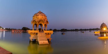 Hindistan, Rajasthan, Gadisar Gölü 'ndeki yüksek kubbeli tarihi Chhatri' nin panoramik manzarası alacakaranlık sırasında çekildi.