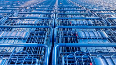 Birçok mavi alışveriş arabaları süpermarketin dışında dizilmiş ve dizilmiştir..