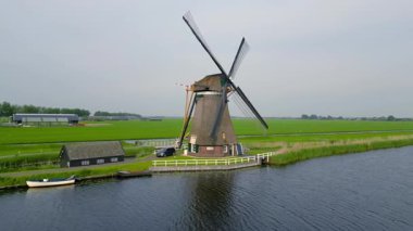 Groot-Ammers, Hollanda - 12 Mayıs 2023: Hollanda 'daki Ammersche Boezem nehri boyunca Achtkante molen.