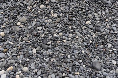 İzlanda 'daki siyah kumsaldaki pürüzsüz siyah çakıl taşlarının yakın görüntüsü.