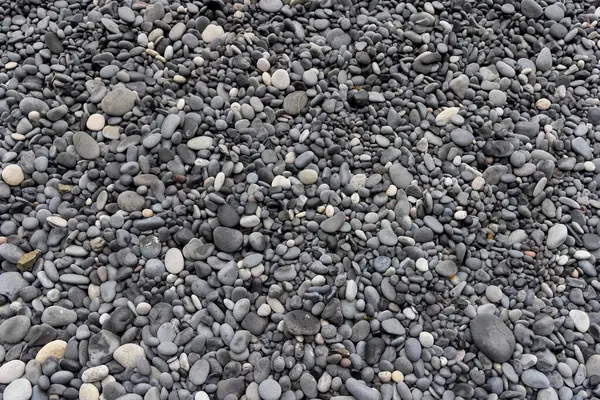İzlanda 'daki siyah kumsaldaki pürüzsüz siyah çakıl taşlarının yakın görüntüsü.