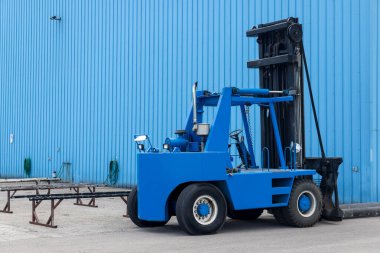 Michigan 'daki endüstriyel binanın yanında mavi bir forklift var..