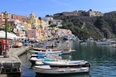 Procida 'nın panoramik manzarası: renkli evler, kafeler ve restoranlar, Marina Corricella' da balıkçı tekneleri ve yatlar, Napoli Körfezi, Campania, İtalya