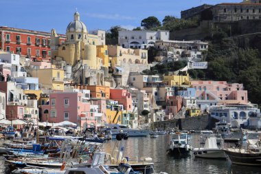 Procida 'nın panoramik manzarası: renkli evler, kafeler ve restoranlar, Marina Corricella' da balıkçı tekneleri ve yatlar, Napoli Körfezi, Campania, İtalya