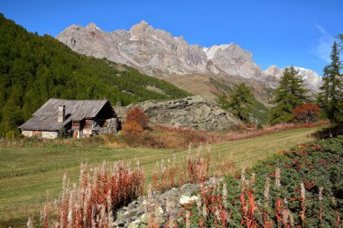 Nevache köyü üzerinde Vallee de la Claree 'de (Claree Vadisi) bulunan geleneksel ahşap dağ evi, Hautes Alpes (Fransız Güney Alpleri), Fransa' nın dağlarla çevrili