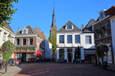 WEESP, NETHERLANDS - SEPTEMBER 21, 2022: The historic city center of Weesp, a small town located in the East of Amsterdam, North Holland, with historic houses along Nieuwstraat street and the Roman Catholic Saint Lawrence (Laurentius) church