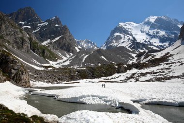 Vanoise Ulusal Parkı, Kuzey Fransız Alpleri, Tarentaise, Savoie, Fransa ve dağlarla çevrili Vaches (Vaches Gölü) karla kaplıdır (Grande Casse zirvesi).)
