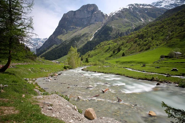 Dağ deresi Doron de Chaviere, Pralognan la Vanoise 'in yukarısındaki Chaviere vadisi boyunca yer alır, Vanoise Ulusal Parkı, Kuzey Fransız Alpleri, Tarentaise, Savoie, Fransa' nın arka planında Les Prioux köyü bulunur.