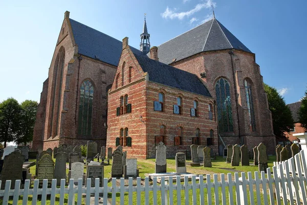 Workum, NETHERLANDS - 12 Temmuz 2023: Grote veya Gertrudiskerk (Greater or St Gertrude Church), ön planda mezarları olan