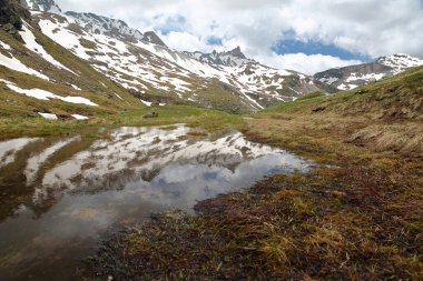 Sassiere vadisinde (Grande Sassiere doğal rezervi), Tignes, Kuzey Fransız Alpleri, Savoie, Fransa 'da bulunan Rhemes Golette buzuluna giden dağ zirvelerinin yansıması.