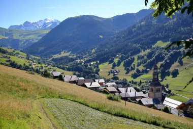 The village Hauteluce, Beaufortain, Savoie, France, a ski resort surrounded by mountain pastures and with the Mont Blanc in the background on the left clipart