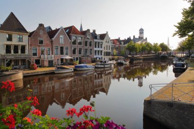 Reflections of traditional houses, barges and boats on the little canal (klein Diep) in Dokkum, Friesland, Netherlands, with the Oud Stadhuis (Old Town Hall, built in 1610) in the background clipart