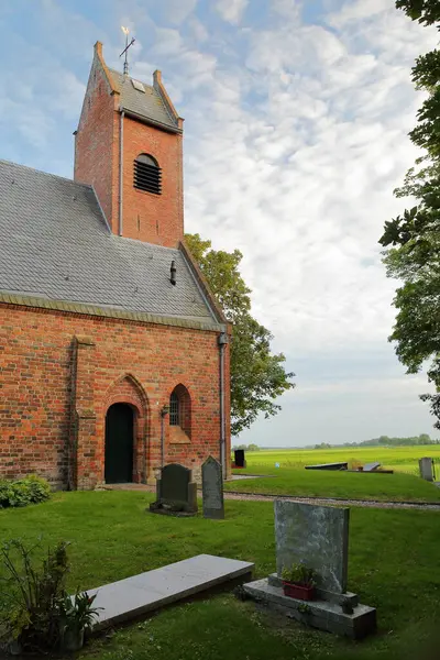 Waaxens (Dokkum yakınlarındaki), Friesland, Hollanda 'daki saat kulesi ve mezarlığıyla ıslah olmuş kilise.