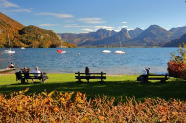 SAINT GILGEN, SALZKAMERGUT, AUSTRIA - 17 EKİM 2024: Saint Gilgen 'deki Wolfgangsee gölünün keyfini çıkaran insanların olduğu renkli sonbahar manzarası