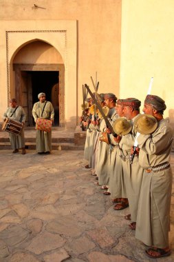 NIZWA, AL DAKHILIYAH, OMAN - 18 Aralık 2024: Razha Folklor dansı, geleneksel olarak Nizwa kalesinde giyinmiş Umman erkekleri tarafından gerçekleştirilen bir kültürel dans 