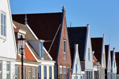 A row of colorful and traditional wooden houses in the village of Durgerdam, North Holland, Netherlands, located near Amsterdam along the dyke of the IJmeer (IJ lake)