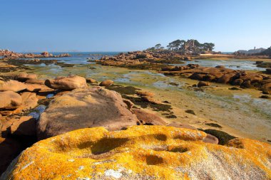 The Cote de Granit Rose (Pembe Granit Sahili) alçak gelgitte Tourony sahilinden, Tregastel, Brittany, Cotes d 'Armor, Fransa, renkli kayalar ve Costaeres Kalesi' nin arka planında görüldü.
