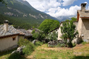 Bramans, Maurienne Valley, Savoie, Kuzey Fransız Alpleri yakınlarındaki bir köy olan Le Chatel 'in evleri ve dağlarla çevrili geleneksel tahta çatıları vardı.