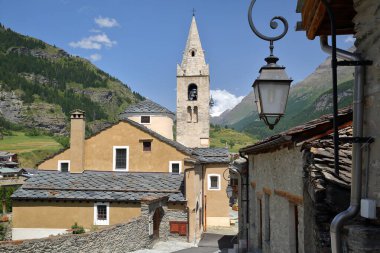 Saint Michel Kilisesi, Lanslevillard, Maurienne Vadisi, Savoie, Kuzey Fransız Alpleri, Fransa, evler ve dağlarla çevrili geleneksel tahta çatılar.
