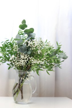 Beyaz arka planı olan beyaz bir masada güzel bir çiçek buketi.