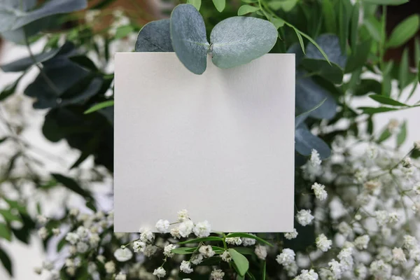 Μια Λευκή Κάρτα Πάνω Από Ένα Μπουκέτο Νυφικών Λουλουδιών — Φωτογραφία Αρχείου