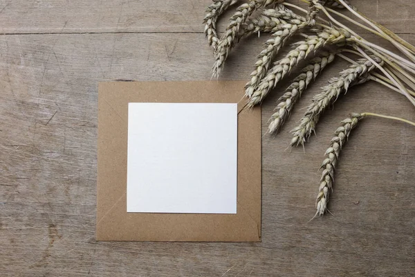Λευκό Χαρτί Σημειώσεων Καφέ Φάκελο Αυτιά Σιταριού Ξύλινο Φόντο — Φωτογραφία Αρχείου