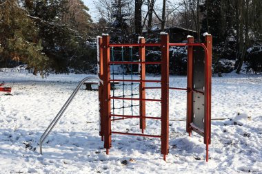 Karla kaplı bir çocuk oyun parkı ile kış manzarası 