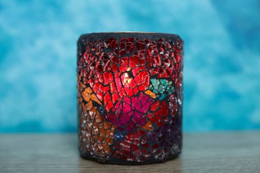 Mavi arka plandaki bardakta mum var. seçici odak.