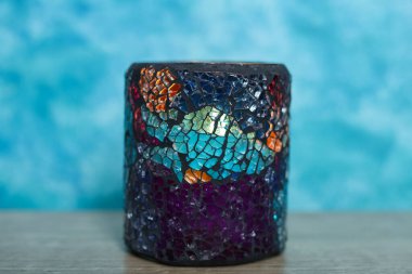 Mavi arka plandaki bardakta mum var. seçici odak.