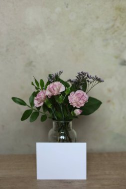 Masasında beyaz çiçekler olan bir kart modeli.