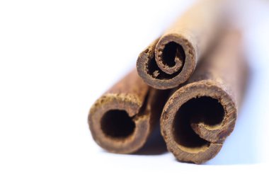 Tarçın çubukları beyaz arka planda izole edilmiş. Seçici odak ve alanın sığ derinliği.