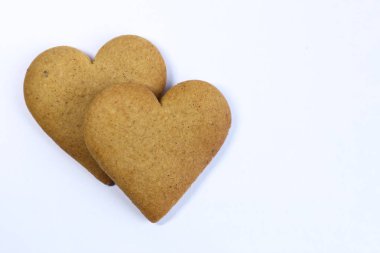 Beyaz arka planda iki kalp şeklinde kurabiye. İzole edilmiş.