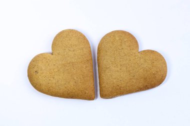 Beyaz arka planda iki kalp şeklinde kurabiye. İzole edilmiş.