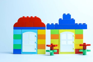 Beyaz arka planda izole edilmiş plastik oyuncak bloklarından yapılmış ev. 