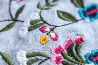 Kumaş arka planda nakış çiçekleri. El yapımı. Seçici odak.