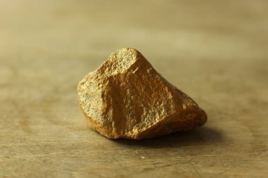 Tahta zemin üzerinde altın taş