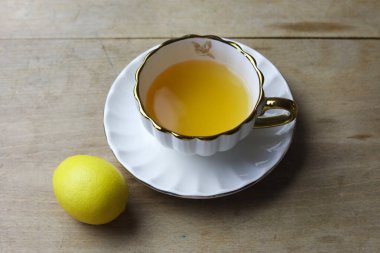 Tahta masada çay fincanı ve limonla hayat devam ediyor. kopyalama alanı ile.