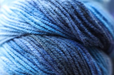 Arka plan olarak mavi yün lekeleri, yakın plan. Örgü örmek için iplik