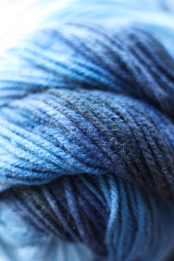 Arka plan olarak mavi yün lekeleri, yakın plan. Örgü örmek için iplik