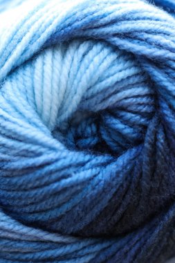 Arka plan olarak mavi yün lekeleri, yakın plan. Örgü örmek için iplik