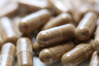 Bir yığın kahverengi hapın yakın plan çekimi, sığ alan derinliği