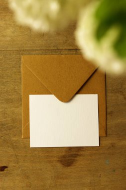 Tahta bir arka planda zarf ve beyaz kartopu viburnum çiçekleri. Metin için yer.