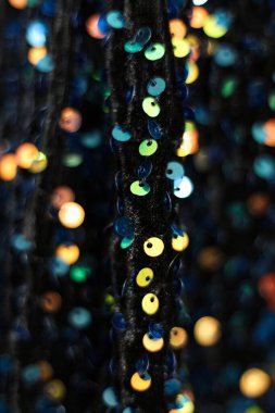 Arka plan olarak siyah kumaş üzerindeki renkli pullar. makro