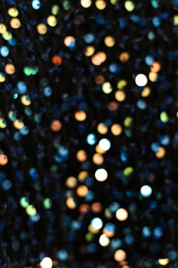 Arka plan olarak siyah kumaş üzerindeki renkli pullar. makro