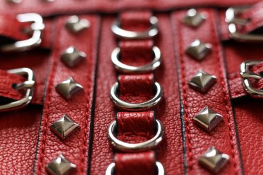 Gümüş perçinli kırmızı deri, yakın çekim makro fotoğraf.