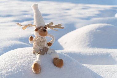 Karlı arazideki Noel geyiği figürü. Komik kış günü ve Noel ruhu kavramı.