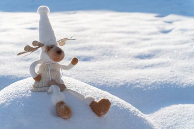 Karlı arazideki Noel geyiği figürü. Komik kış günü ve Noel ruhu kavramı.